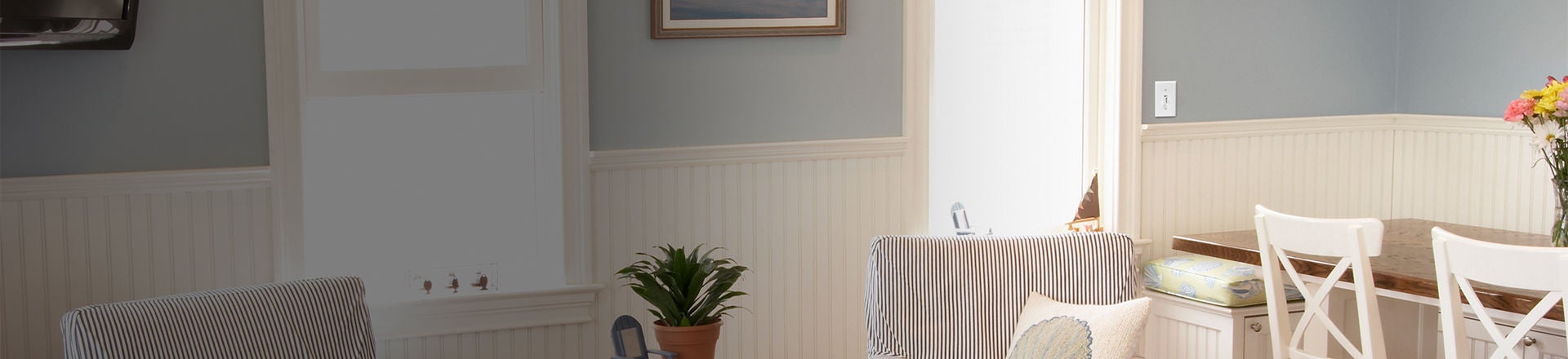 light colored dining room with toggle slide dimmer on the wall beside a window