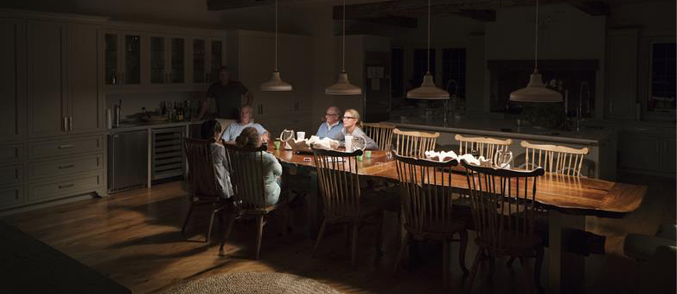 Family sitting around table talking under dimmed overhead light